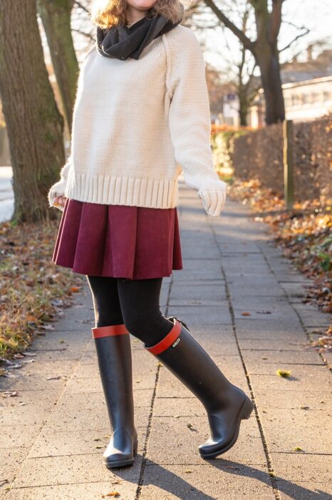 Absatzgummistiefel im Herbst mit rotem Minirock und Strickpullover