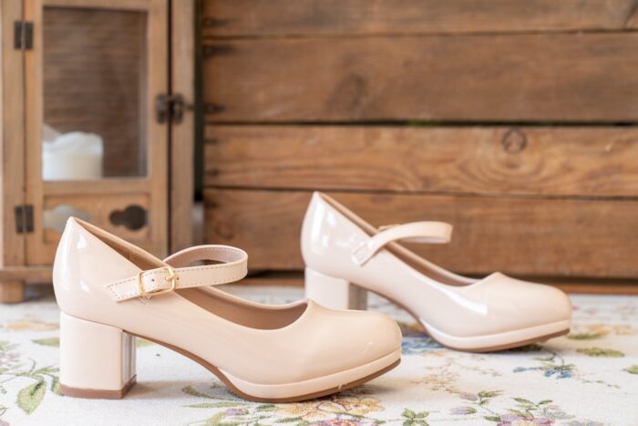 Beige Mary Jane Pumps von Tulleen vor rustikaler Holzwand - passend für festliche Anlässe