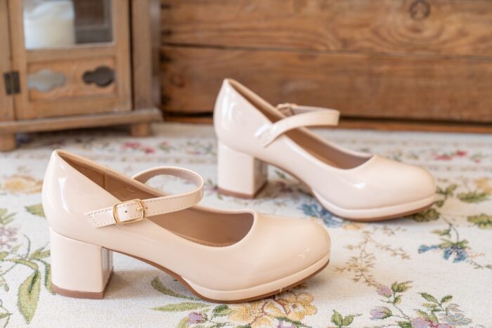 Beige Tulleen Pumps in Lackoptik mit Mary Jane Riemchen auf floralem Teppich